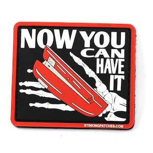 Op de afbeelding: Een zwart-witte patch met een rode nietmachine in een skelet hand. De tekst luidt "NOW YOU CAN HAVE IT" en "STINKINGPATCHES.COM".