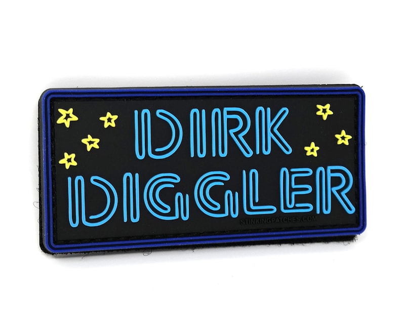 May include: A black patch with blue and yellow neon lettering that reads "DIRK DIGGLER" with yellow stars around the text. The patch has a blue border and the text "STINKINGPATCHES.COM" is printed in white at the bottom.