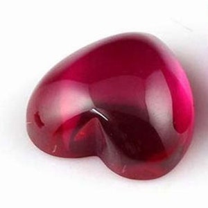 May include: A deep red heart-shaped gemstone with a smooth, polished surface.