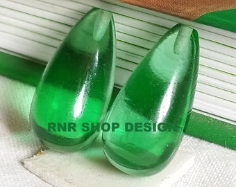 Puede incluir: Dos cuentas de vidrio verde en forma de lágrima. Las cuentas son translúcidas y tienen un acabado liso y brillante. RNR SHOP DESIGN está impreso en las cuentas.