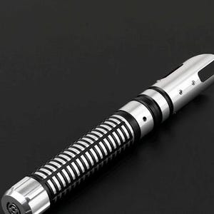Pu&ograve; includere: Un'elica di spada laser argento e nera con un design dettagliato. L'impugnatura presenta un motivo a coste e accenti neri, mentre l'emettitore ha un design a fessura distintivo. L'estetica generale &egrave; elegante e futuristica.