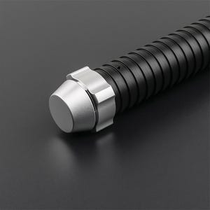 May include: Close-up of a black and silver lightsaber hilt. The hilt features a ribbed black grip and a silver pommel and emitter. The lightsaber is set against a dark background.