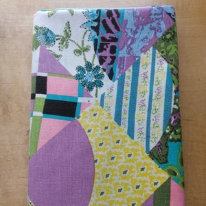 May include: A patchwork fabric with a variety of colors and patterns, including purple, yellow, green, blue, and pink. The fabric is made up of different geometric shapes, including squares, triangles, and circles.