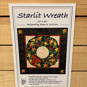 May include: A quilting pattern for a Starlit Wreath, a 22-inch by 22-inch quilt featuring a wreath with red berries and gold stars on a dark green background. The pattern is designed by Eileen B. Sullivan and includes instructions for foundation piecing on freezer paper.