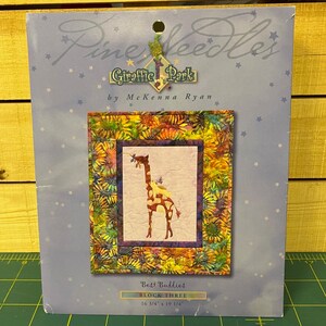 May include: A quilting pattern for a block featuring a giraffe and a bird with a sunflower border. The pattern is titled "Best Buddies Block Three" and measures 16 3/4 inches by 19 1/4 inches.