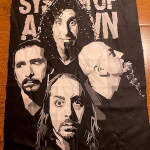 Könnte beinhalten: Schwarzer Stoff mit einem Graustufenbild der Band System of a Down. Der Name der Band ist in großen weißen Buchstaben oben aufgedruckt. Das Bild enthält Porträts der Bandmitglieder.