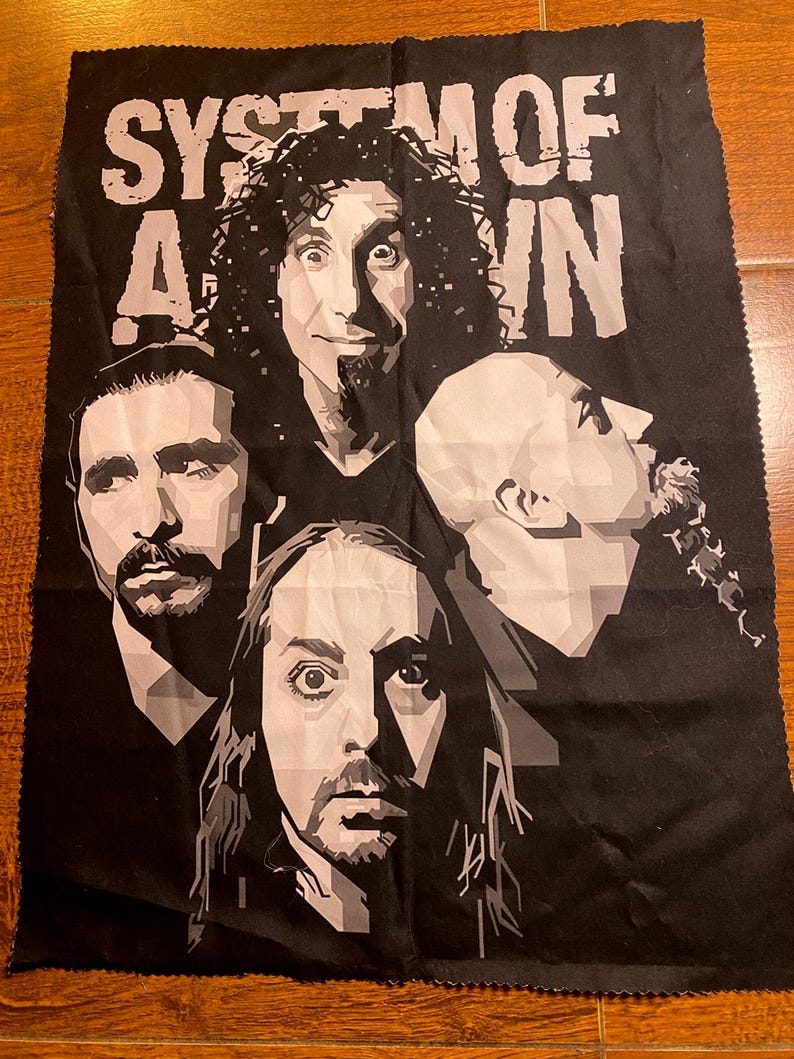 Pode incluir: Tecido preto com uma imagem em tons de cinza da banda System of a Down. O nome da banda &eacute; impresso em letras brancas grandes no topo. A imagem inclui retratos dos membros da banda.
