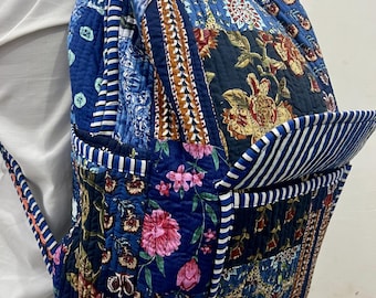 Peut inclure: Un sac à dos patchwork avec une variété de tissus floraux et à motifs bleus. Le sac à dos a une poche avant avec des rayures blanches et bleues et des bretelles réglables. Le design comprend des motifs floraux et cachemire dans les tons de bleu, marron et rose.