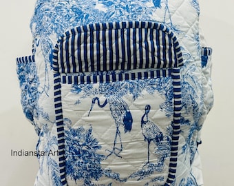 Peut inclure: Sac à dos matelassé blanc et bleu avec un motif inspiré de la nature. Le sac à dos présente un motif de toile de Jouy bleu et blanc avec des oiseaux et du feuillage. La poche avant est ornée de rayures verticales bleues et blanches. Il possède deux poches latérales et une poignée supérieure.