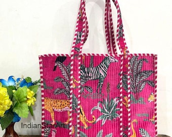 May include: A pink tote bag with a jungle animal print featuring zebras, leopards, and tropical plants. The bag has a corduroy texture and white and red striped trim. The handles are also pink with the same striped trim. The text "IndianStarArt" is visible.