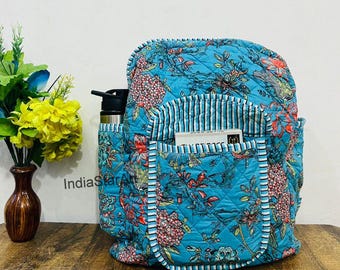 Peut inclure: Sac à dos matelassé turquoise avec un motif floral rouge et rose. Il comporte plusieurs poches, dont une latérale pour une bouteille d'eau. L'intérieur est doublé de rayures. Le sac à dos est fait d'un motif matelassé.