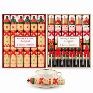May include: Two boxed sets of Harvey & Mason 8 Saucer Crackers. One box features gingerbread-style characters, the other nutcracker designs. Each cracker is wrapped in kraft paper with red bows. A single gingerbread cracker rests on a white teacup and saucer.
