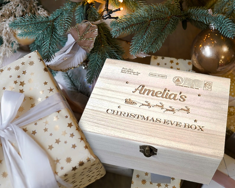 Puede incluir: Una caja de madera para la v&iacute;spera de Navidad con una inscripci&oacute;n personalizada que dice "Amelia's Christmas Eve Box". La caja est&aacute; decorada con un dise&ntilde;o de renos y trineo y tiene un cierre de lat&oacute;n.