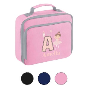 May include: A pink lunch bag with a grey handle and trim. It features a ballerina graphic, the letter "A", and the name "Amelia". The bag has a zip closure and a front pocket.