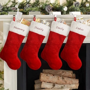 May include: Four red and white Christmas stockings with the names "Mummy", "Daddy", "Emily", and "Lukas" embroidered on them.