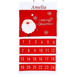 May include: Red and white Christmas advent calendar with the name "Amelia" at the top. The calendar features a Santa Claus design, snowflakes, and the words "merry Christmas." Numbers 1-24 are displayed in individual pockets.