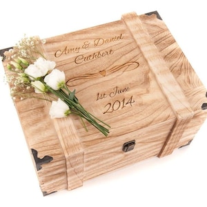 May include: A wooden box with a hinged lid and metal clasps. The box is engraved with the text "Amy & Daniel Cuthbert, 1st June 2014".