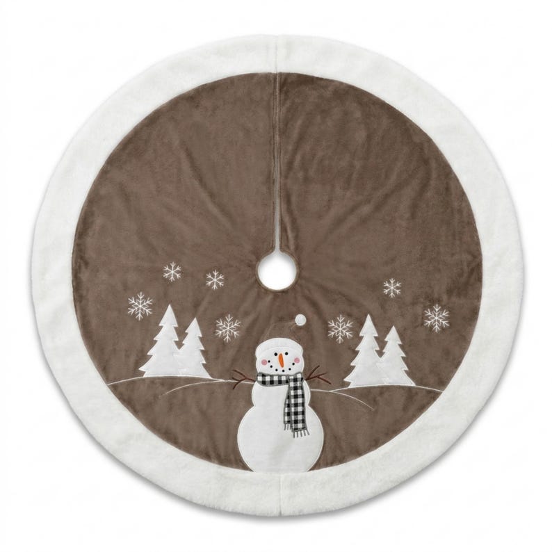May include: A round Christmas tree skirt featuring a brown velvet centre with a white plush border. The design includes a white snowman wearing a black and white buffalo check scarf, surrounded by white embroidered pine trees and snowflakes.