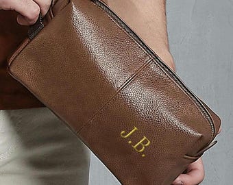 May include: A brown leather zipped pouch with the initials "J.B." embroidered in gold thread.