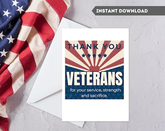May include: A white greeting card with the text "THANK YOU VETERANS" in red and blue, with a vintage design. The card is placed next to an American flag.