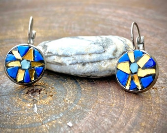 May include: A pair of silver hoop earrings with blue and gold mosaic designs. The mosaic features a starburst pattern with blue and gold tiles.