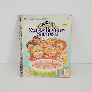 Puede incluir: Un libro de oro vintage "Cabbage Patch Kids Presents Xavier's Birthday Surprise!". La portada presenta ilustraciones de Cabbage Patch Kids alrededor de una tarta de cumpleaños. El libro tiene una etiqueta de precio.
