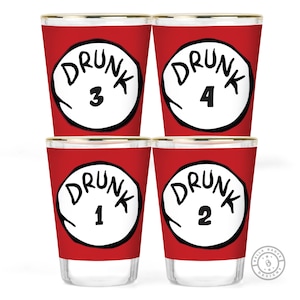 May include: Four shot glasses with a red background and gold rims. Each glass has a white circle with the word "DRUNK" and a number from 1 to 4 in black. A fun and playful design for parties and gatherings.
