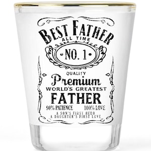 May include: A clear glass shot glass with a gold-toned rim featuring black printed text that reads Best Father All Time No. 1 Quality Premium World's Greatest Father 90% Patience 100% Love A Son's First Hero A Daughter's First Love.