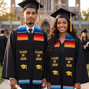 May include: Two graduates wearing black graduation gowns and mortarboards, holding diplomas. They have colorful stoles with the text "CLASS OF 2026" and a yellow graduation cap icon. The background features a stone building.