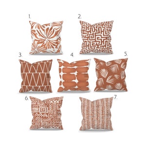 Peut inclure: Sept designs différents d'oreillers avec divers motifs géométriques dans des tons de brun et de blanc. Les oreillers sont numérotés de 1 à 7.