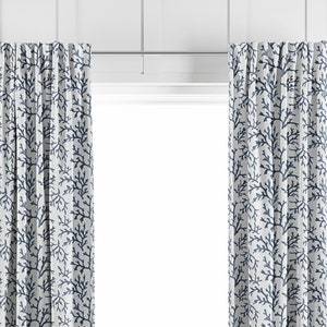 May include: A pair of white curtains with a blue coral reef pattern. The curtains are hung on a silver curtain rod.