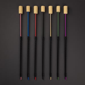 Puede incluir: Un conjunto de siete poi de fuego, cada uno con un mango negro y un eje de diferente color: rosa, azul, rojo, negro, dorado, verde y morado. La parte superior de cada poi tiene una cabeza cilíndrica de color beige.