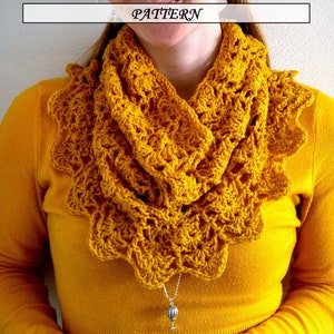 May include: A yellow crocheted infinity scarf with a scalloped edge. The scarf is worn by a person with a yellow shirt.