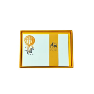May include: A set of stationery in a yellow box. The stationery features a hot air balloon with a horse illustration and the text "MUSTARD & GRAY". The box and stationery have a yellow and white color scheme.