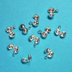 May include: Ten silver-toned metal clasps with a ball-shaped design. Each clasp has two loops for attaching to jewellery or other crafts.