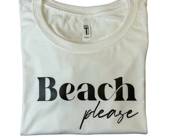 May include: White t-shirt with black text that says "Beach please" in a stylized font.