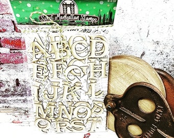 May include: A package of wooden alphabet letter stamps in a clear plastic bag. The bag is tied with twine and has a green and white label that says "Sweet Manhattan Stamps".