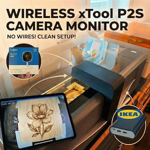 May include: Image of a wireless xTool P2S camera monitor setup. The image shows a tablet displaying a wood-burned flower design, a Tapo camera box, and a black power bank with the IKEA logo. The text "WIRELESS xTool P2S CAMERA MONITOR" is displayed.