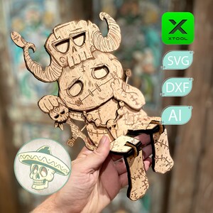 Pode incluir: Um recorte de madeira de um personagem de desenho animado com uma cara de caveira, chifres e um corpo costurado. O personagem está sentado em uma cadeira com um design de caveira e ossos cruzados. O recorte está na mão de uma pessoa.
