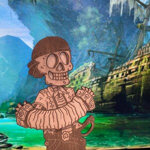 May include: A laser-cut wooden cutout of a skeleton pirate wearing a bandana and a vest, playing an accordion. The figure features engraved details including a skull and crossbones on the sleeve cuffs, a belt with a spiral buckle, and a sword.