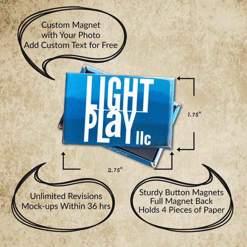 May include: A rectangular blue button magnet featuring the white text LIGHT PLAY llc. The magnet measures 2.75 inches by 1.75 inches and has a full magnetic back. The design includes a gradient blue background with a mountain silhouette graphic.