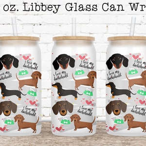 May include: Three 16 ounce white Libbey glass can wraps with a brown wood lid. The wraps feature a repeating pattern of dachshund dogs in black and brown with the text "I love my dachshund" repeated throughout.