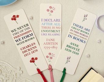 May include: Three cream-colored bookmarks with floral designs and quotes about books. The bookmarks feature quotes from Charles Dickens, Jane Austen, and Anne Brontë, along with their birth and death years.