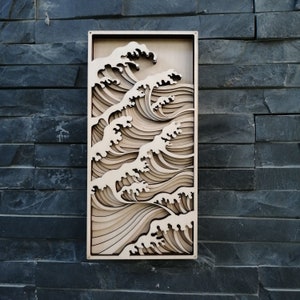 May include: A wooden wall art piece depicting a layered wave design. The wave is made of multiple layers of wood, creating a 3D effect. The piece is painted in a light brown color.