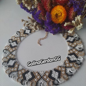Könnte beinhalten: Eine weiße, schwarze und goldene Perlenkette mit geometrischem Muster. Die Kette besteht aus kleinen Perlen und hat einen zarten, femininen Look. Der Text "GalinaGerdanGG" ist auf der Kette sichtbar.