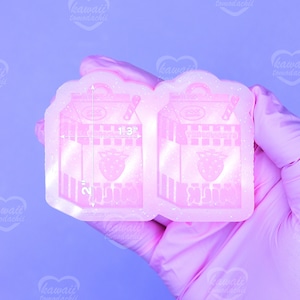 May include: A pink resin mold in the shape of a strawberry milk carton. The mold is 2 inches tall and 1.3 inches wide. The carton design includes a strawberry graphic and the text "YooHoo Strawberry Milk".