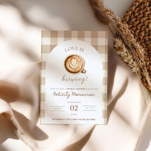 Könnte beinhalten: Einladung zur Brautparty mit Kaffeethema. Die Einladung zeigt ein Latte-Art-Design mit dem Text "Love is brewing!" und Details für Felicity Merrimans Party am 2. November 2025 um 14:00 Uhr.