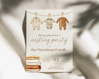 May include: A cream-colored invitation card featuring a watercolor illustration of three baby onesies hanging on a clothesline. Text reads: Please join us for a nesting party for the Merriman Family, Sunday, November 02, 2025, at 2 PM, 123 Main St, City.