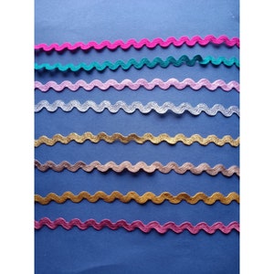 May include: Assortment of eight wavy trim ribbons in various colors, including pink, teal, light pink, silver, gold, peach, gold, and magenta.