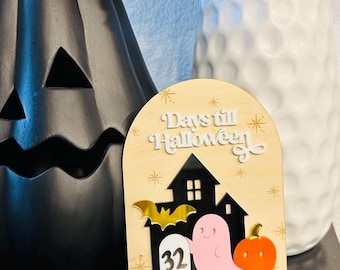 May include: A wooden Halloween countdown sign with the text "Days till Halloween". The sign features a black house, a gold bat, a pink ghost, and an orange pumpkin. The number 32 is displayed.